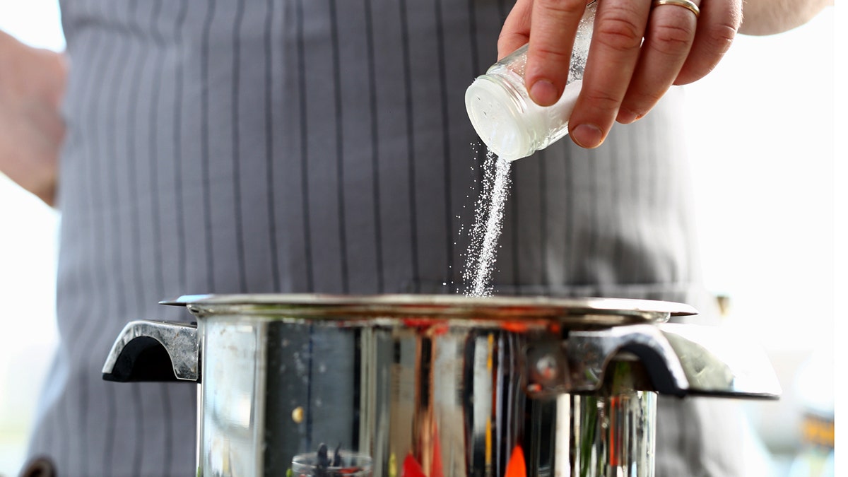 Un homme verse du sel dans un pot